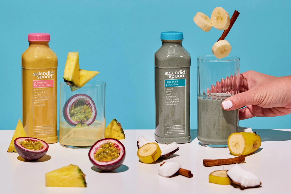 Smoothie bottles with tropical fruit and a hand pouring a glass